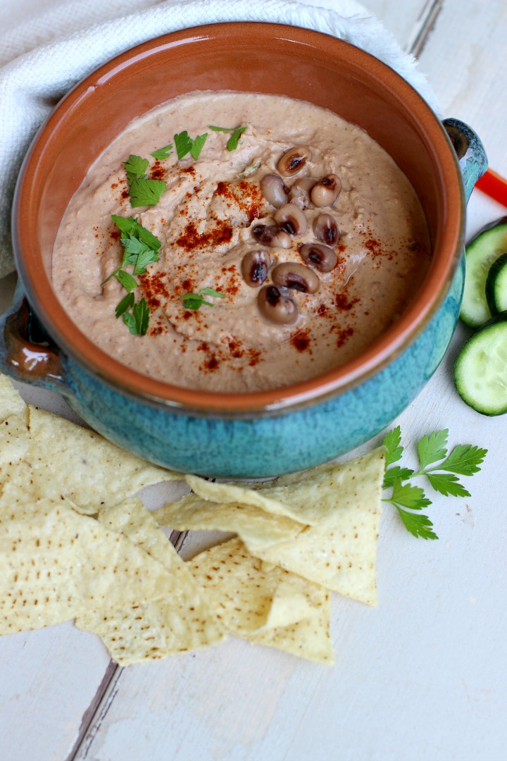 small blue crock with black eyed pea hummus with parsley and smoked paprika garnish