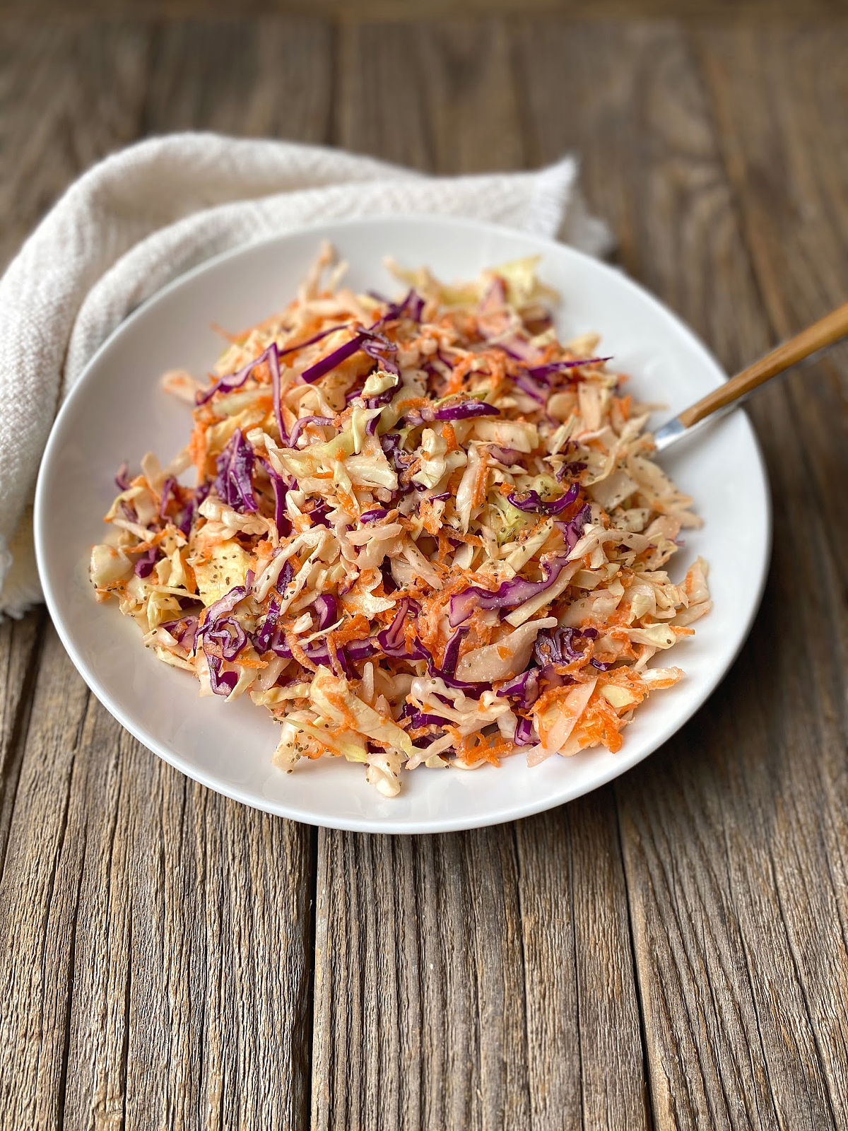 White bowl on a rustic surface with healthy coleslaw